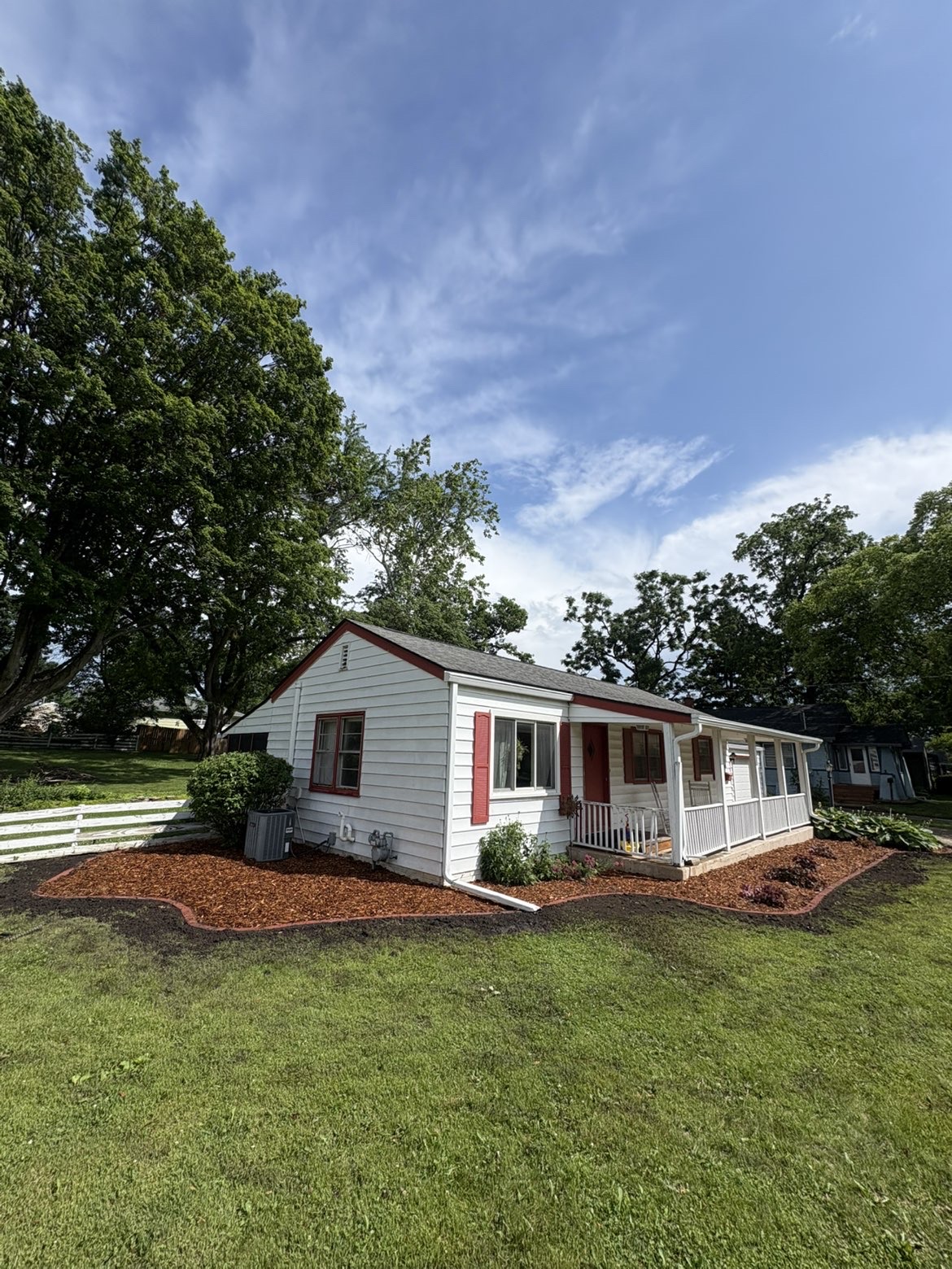 Residential mulch bed installation wrapping home exterior with fresh edging in Des Moines Iowa