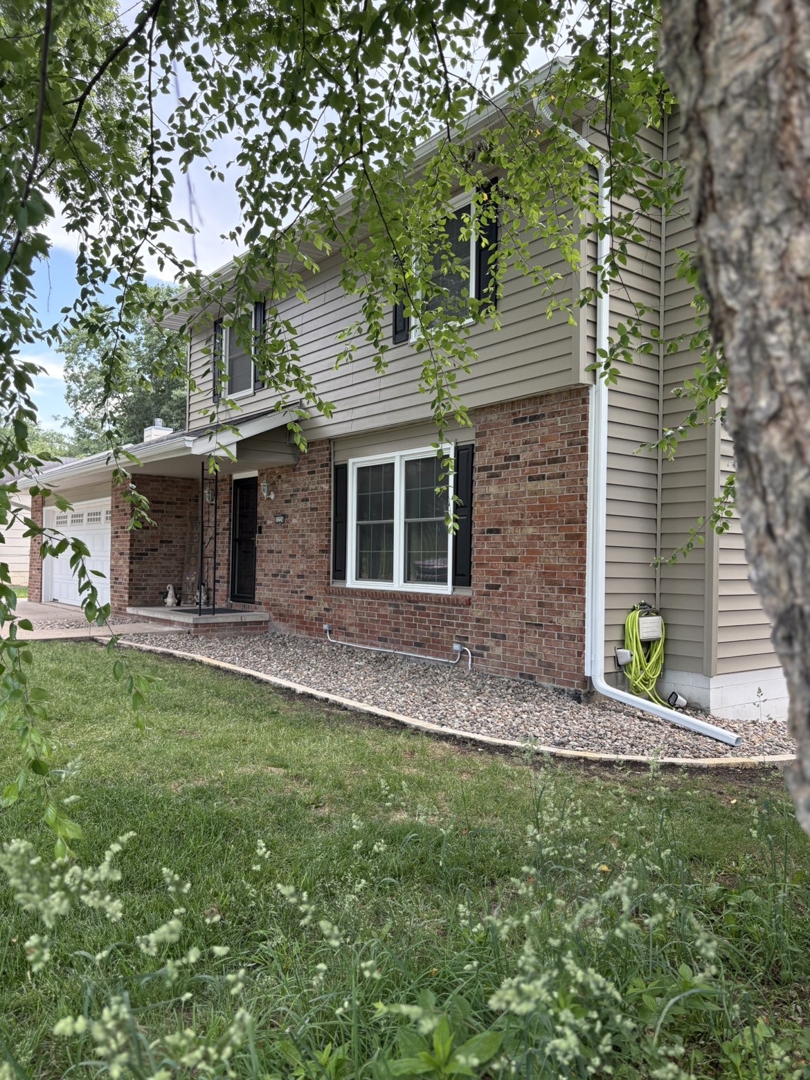 Residential foundation landscaping with rock beds and stone edging in Des Moines Iowa