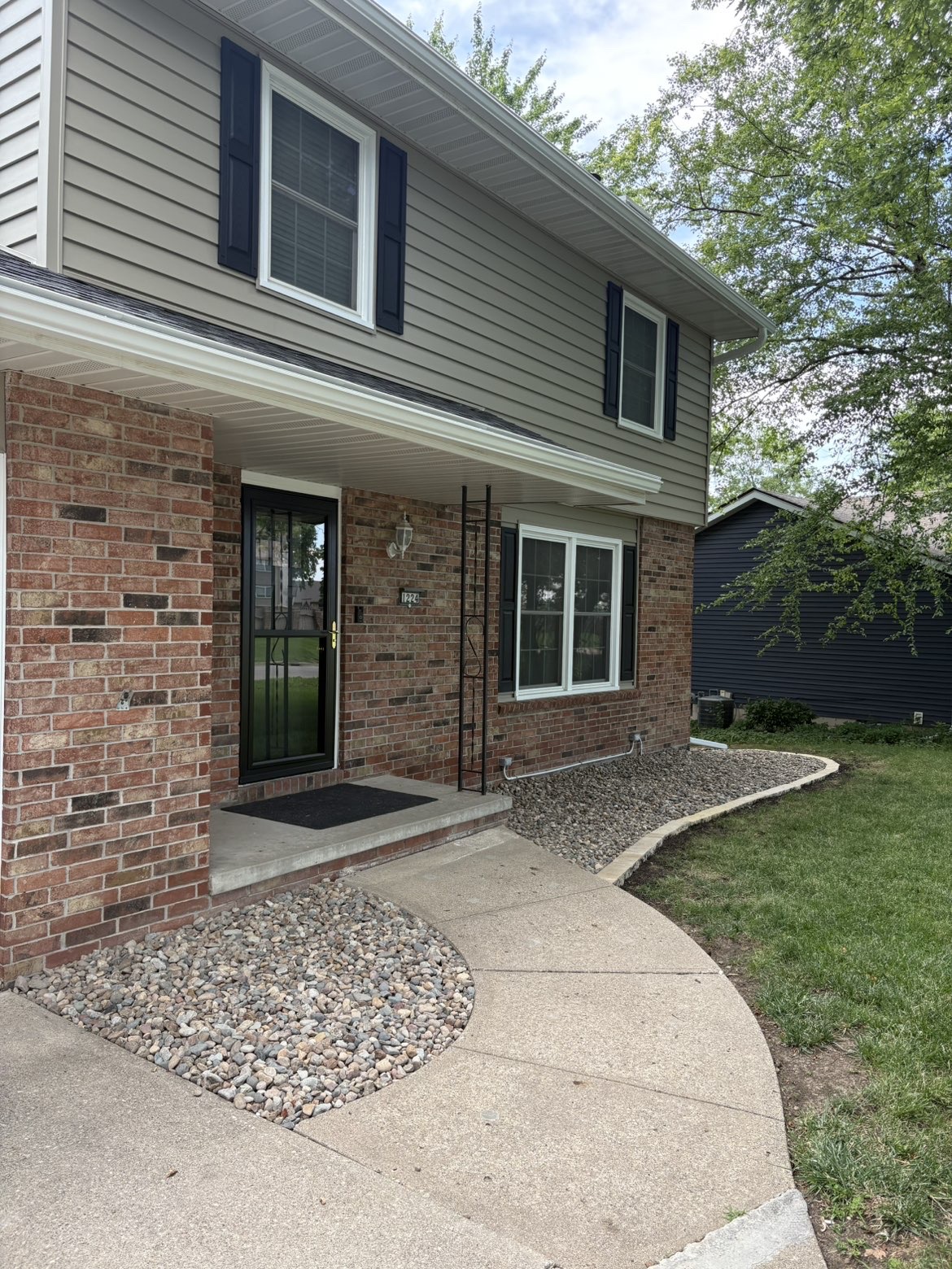 Rock landscaping foundation bed installation with river rock at Des Moines home entry
