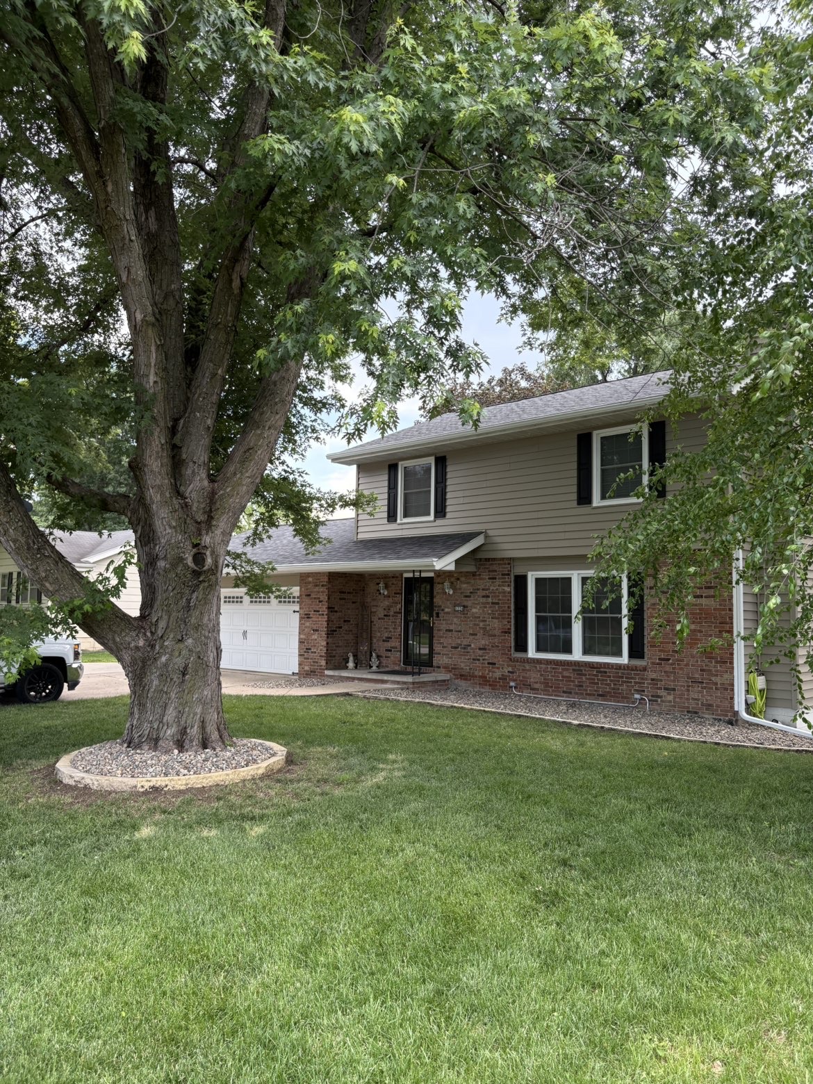 Front yard landscaping and home exterior improvement with mature tree ring in Des Moines Iowa