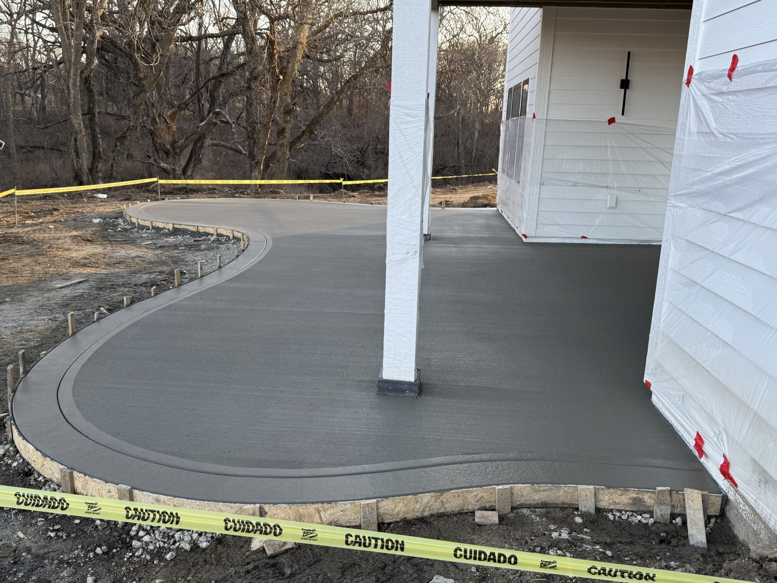 Fresh concrete pour wrapping around new construction home