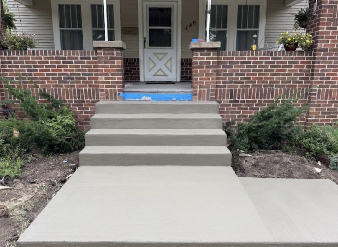 Concrete front steps and landing at brick home