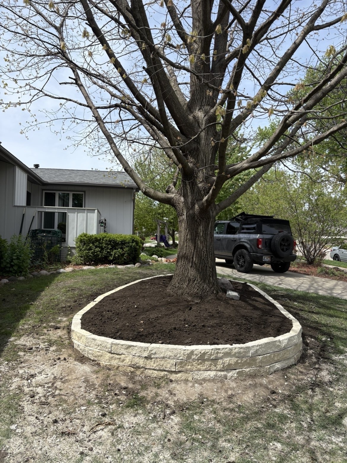 Custom masonry stone tree ring border by Des Moines contractor in Johnston