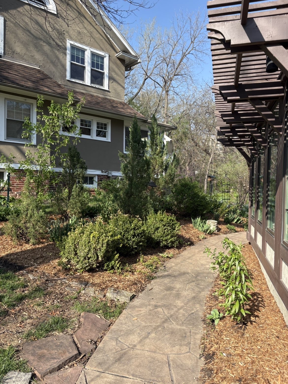 Stamped concrete pathway with mulched plantings and pergola in Urbandale Iowa