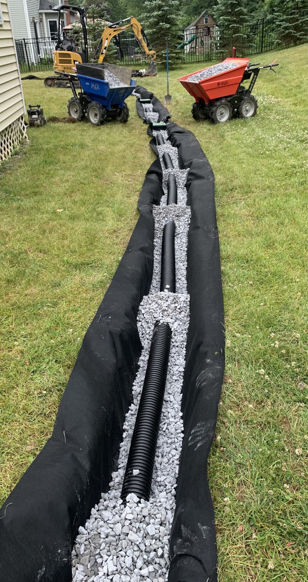 Corrugated drain pipe installation with equipment on site