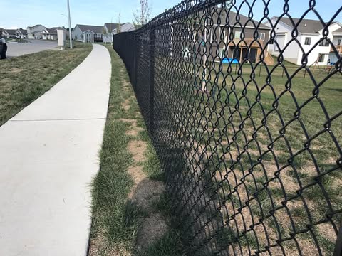 Black chain link fence along sidewalk in Des Moines neighborhood