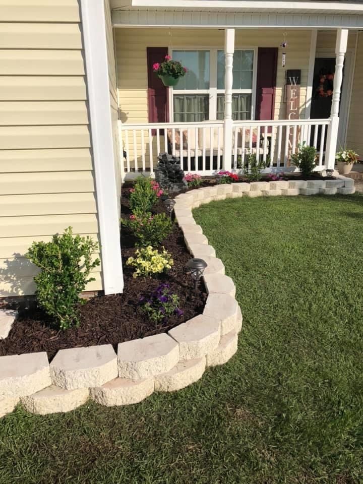 Front porch landscape bed with stone border and fresh plantings