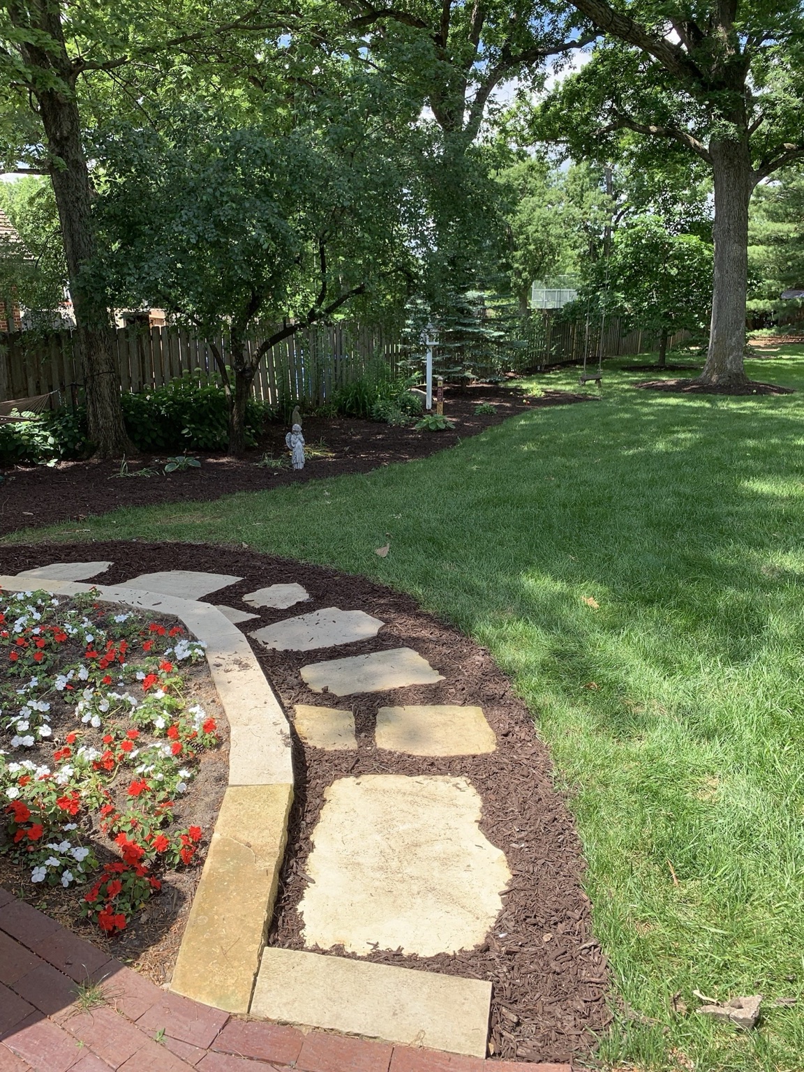 Flagstone pathway with brick border and flower beds in Des Moines
