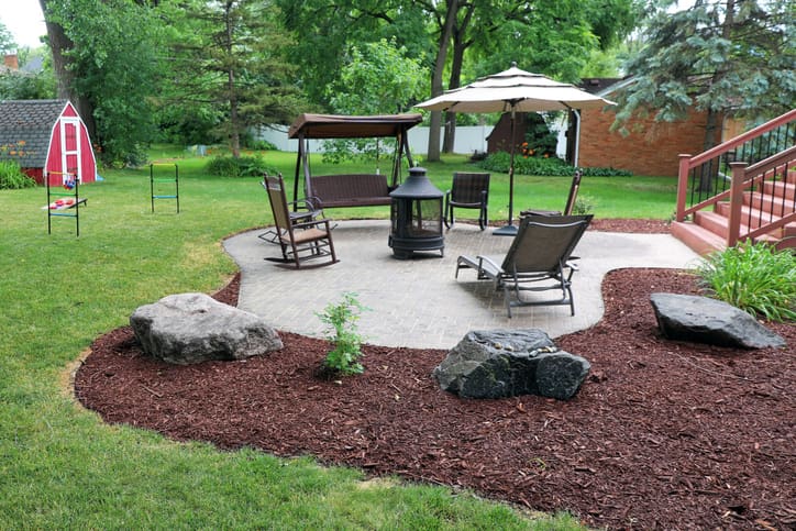 Mulch bed with decorative boulders around paver patio in Des Moines
