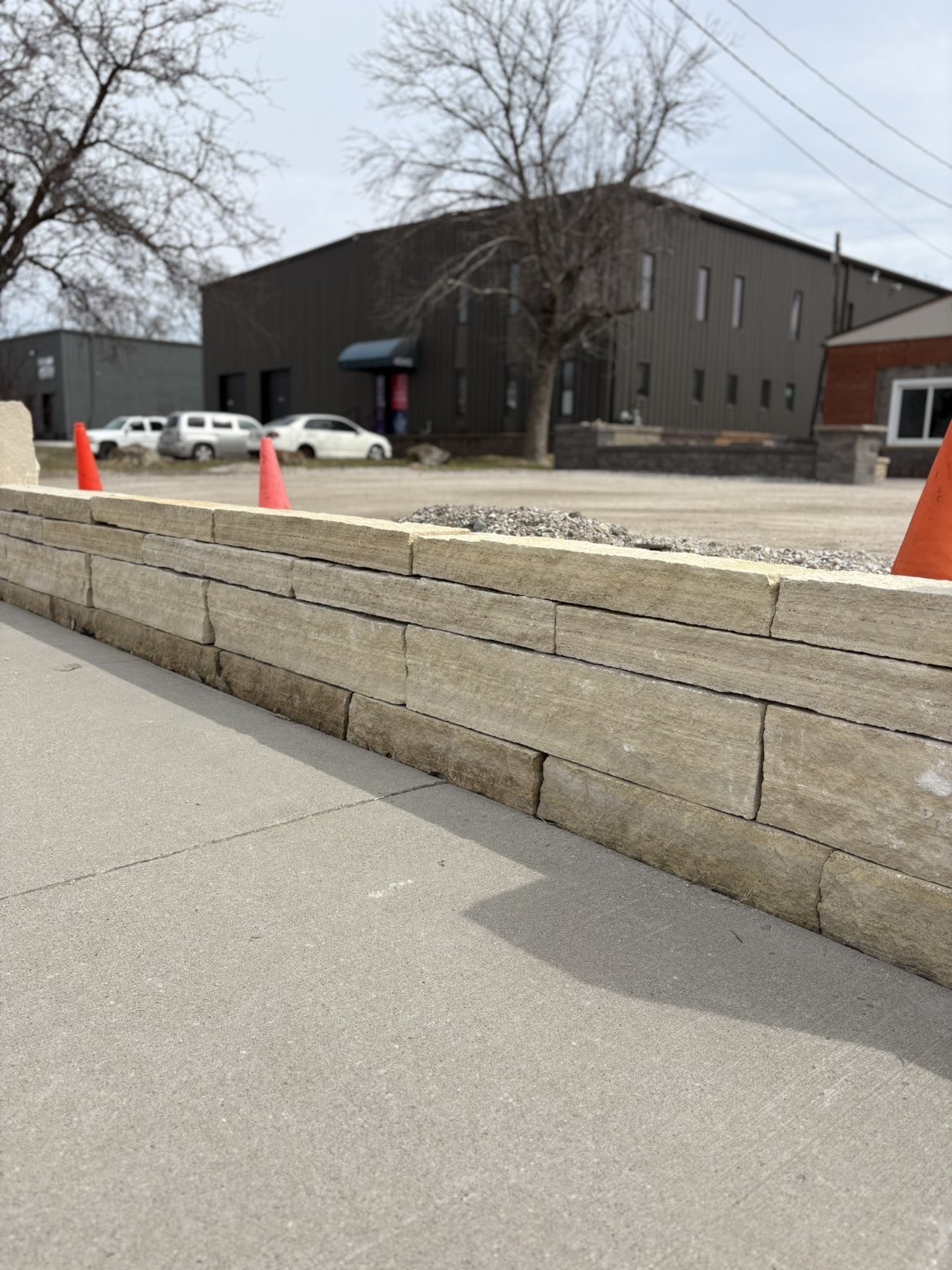 Commercial stone retaining wall with concrete sidewalk