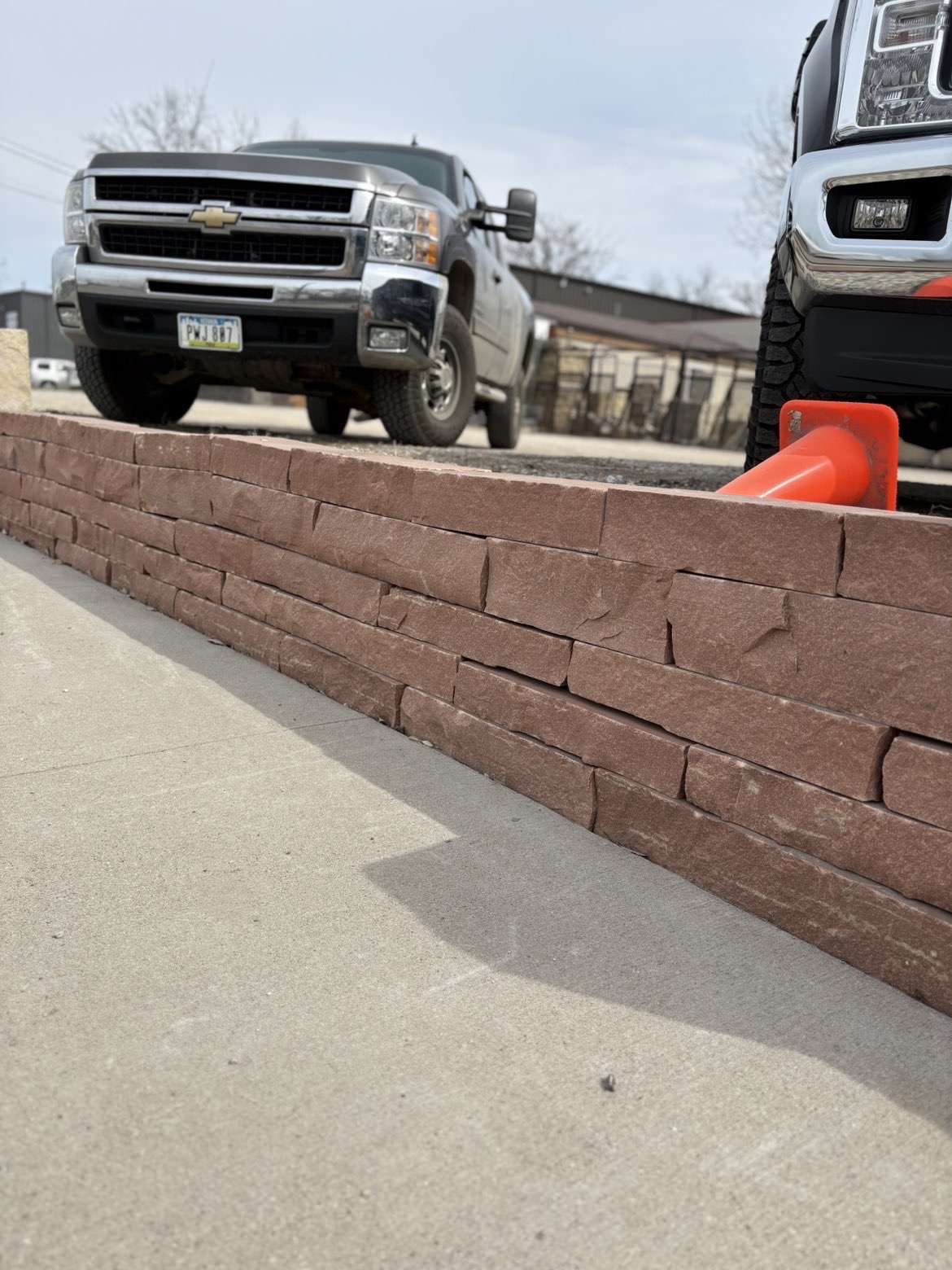 Brown stone retaining wall with sidewalk edging