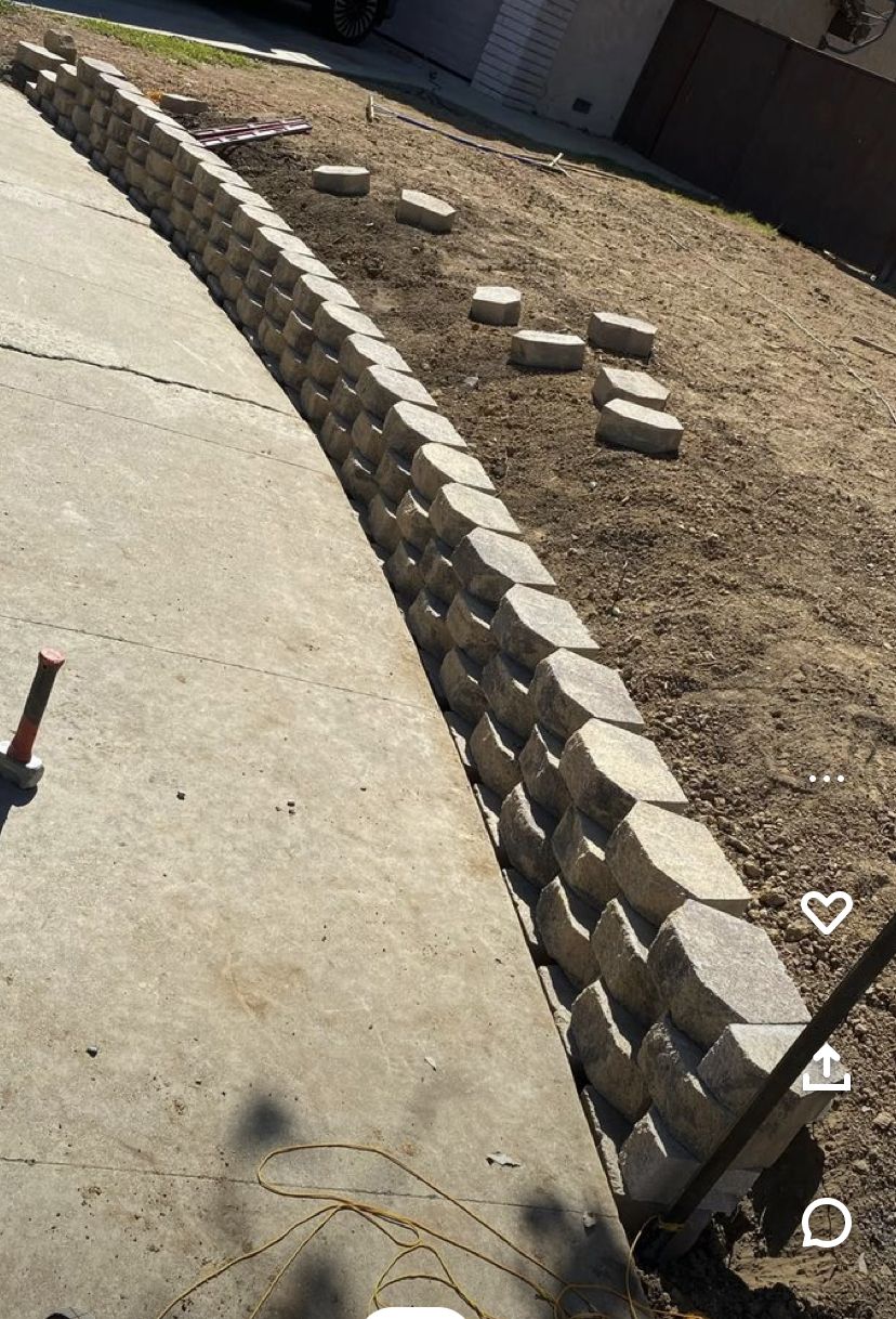 Three-stack block retaining wall along concrete driveway